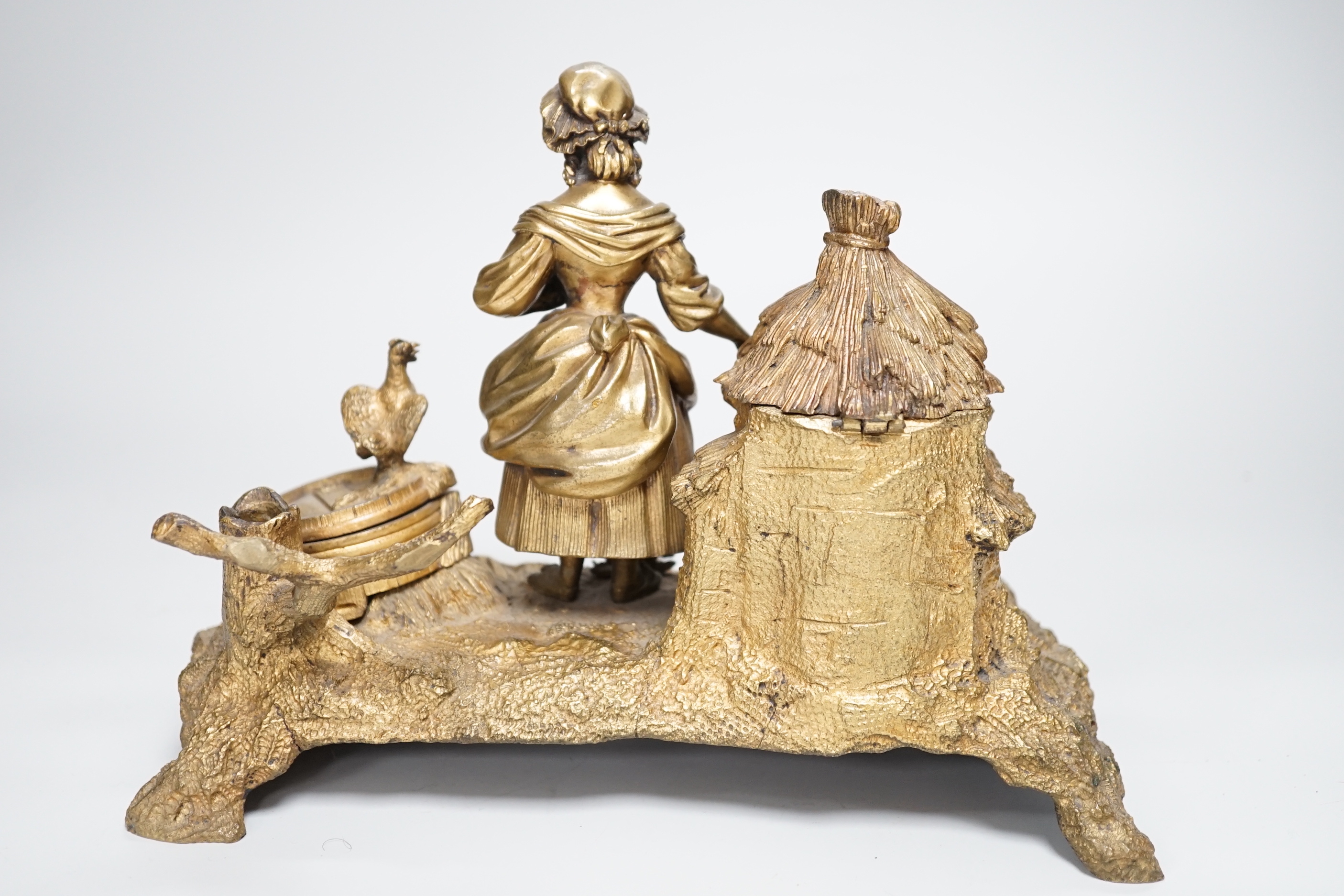 A 19th century gilt bronze inkwell decorated with a farmyard scene and country maiden, 18cm high